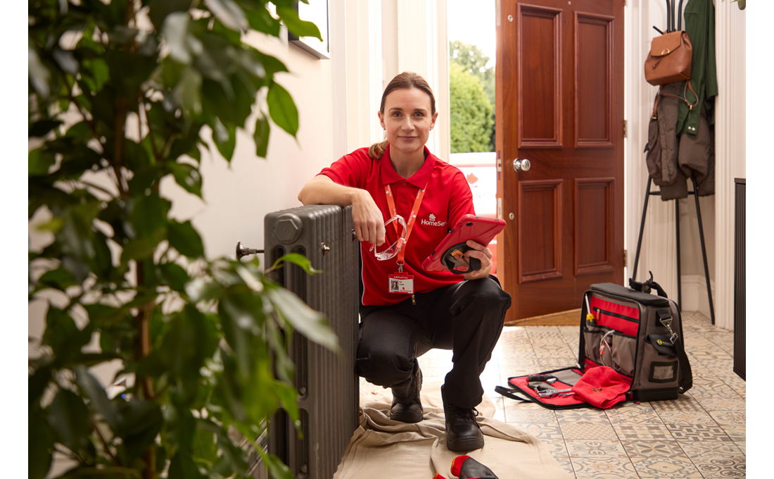 A HomeServe heating engineer fixing a cold radiator and running through essential checks on her tablet