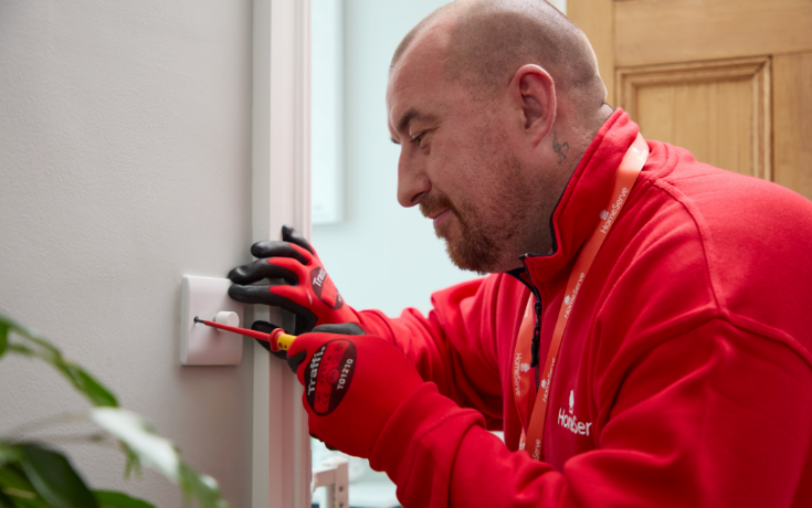 A HomeServe electrician repairing a dimmer light switch