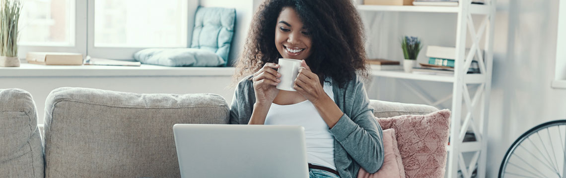 Person smiling whilst looking at HomeServe's offers on a laptop